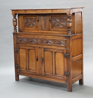 A reproduction 17th Century Ipswich style carved and inlaid oak court cupboard, the upper section enclosed by a pair of panelled doors above 2 drawers, above cupboard enclosed by pair of panelled doors 136cm h x 127cm w x 48cm d 