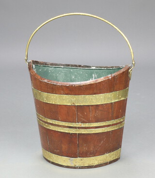 A Regency style oval boat shaped mahogany and brass coopered kindling/waste paper basket with brass swing handle 34cm h x 39cm w x 26cm d, complete with metal liner 
