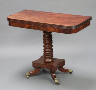 A 19th Century mahogany D shaped card table raised on a ring turned column with triform base, ending in brass paw caps and casters 64cm h x 92cm w x 46cm d 