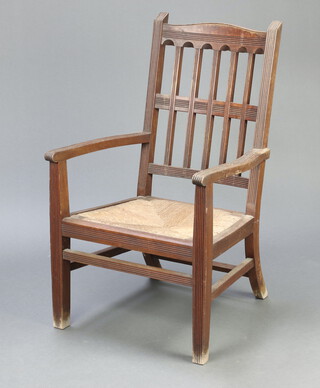 An Arts and Crafts mahogany open armchair with lattice work back and woven rush seat, raised on square supports 98cm h x 56cm w x 57cm d (seat 27cm x 31cm) 
