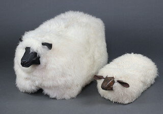 A wooden seat in the form of a Scottish Blackface sheep covered in a complete fleece 45cm h x 93cm w x 43cm d, together with a matching footstool 20cm x 54cm x 28cm 