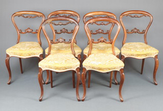 A set of 6 Victorian bleached rosewood balloon back dining chairs with carved mid rail and overstuffed seats of serpentine outline raised on cabriole supports 85cm h x 35cm w x 36cm d 