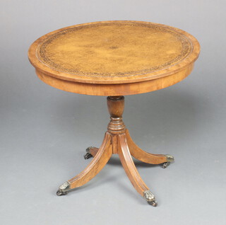 A Georgian style circular mahogany occasional table with brown writing surface to the top, raised on pillar and tripod base 52cm x 60cm diam. 