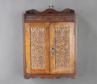 A Victorian carved oak hanging smokers cabinet, the raised back with 3/4 gallery, the interior fitted a pipe rack and 2 drawers enclosed by panelled doors 44cm h x 32cm w x 16cm d 