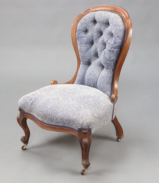 A Victorian mahogany show frame nursing chair of serpentine outline, upholstered in blue buttoned material, raised on cabriole supports 92cm h x 68cm w x 55cm d 