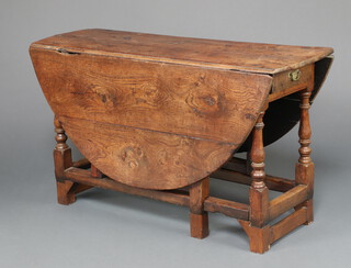 A 17th/18th Century oak oval drop flap gateleg dining table raised on turned supports fitted a frieze drawer, 73cm h x 125cm w x 45cm d 