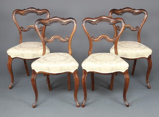 A set of 4 Victorian carved rosewood spoon back dining chairs with shaped mid rails and serpentine fronted overstuffed seats, raised on cabriole supports 83cm h x 47cm w x 37cm d 