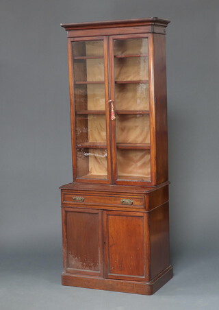 A Victorian mahogany D shaped bookcase on cabinet with moulded cornice, fitted shelves enclosed by glazed panelled doors, the base fitted a drawer above cupboard enclosed by a panelled door, raised on a platform base 200cm h x 75cm w x 49cm d 
