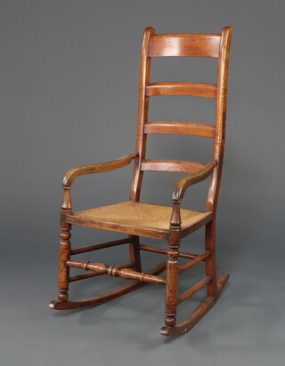 A 19th Century elm ladder back rocking chair with woven rush seat 110cm x 53cm w x 66cm d (seat 29cm x 38cm) 