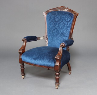 A Victorian carved mahogany open armchair upholstered in blue material raised on turned supports 94cm h x 64cm w x 45cm d (seat 31cm x 32cm) 