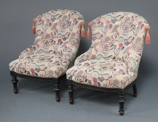 A pair of Victorian mahogany tub back chairs upholstered in pink and blue material, raised on turned supports 81cm h x 59cm w x 46cm d (seats 26cm x 31cm) 
