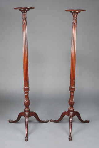 A near pair of Edwardian Chippendale style turned and reeded mahogany torcheres, raised on a pillar and tripod base, egg and claw feet, 160cm h x 25cm 
