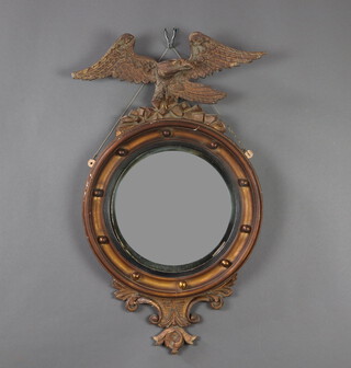 A 19th Century convex circular plate mirror contained in a gilt ball studded frame surmounted by an eagle 41cm x 75cm 