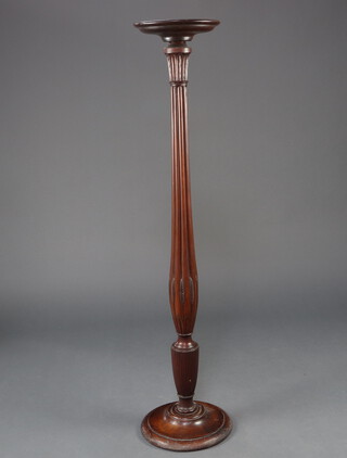 A William IV turned mahogany bedpost torcher with saucer top, raised on a turned column and spreading base 143cm h x 27cm diam.  
