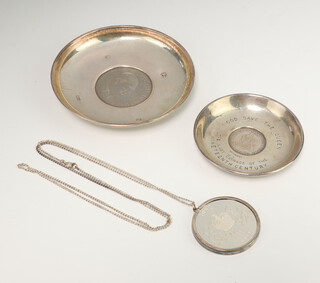 A silver Armada dish set with cupronickel Churchill crown, a smaller ditto together with a mounted commemorative coin and chain, gross weight 133 grams  