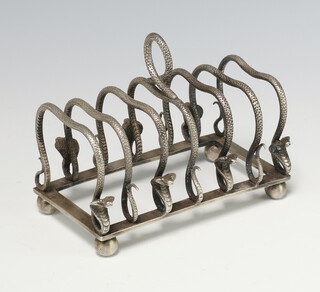 A white metal 7 bar toast rack decorated with cobras, raised on ball feet 