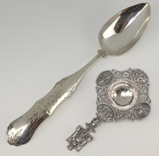 A 19th Century Dutch tablespoon, the back decorated with flowers together with a Dutch repousse tea strainer 