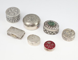 A Continental white metal repousse pill box and 6 others 
