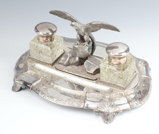 A Victorian silver plated ink stand in the form of an eagle on rocks, flanked by 2 glass inkwells with 2 pen scoops, raised on scroll feet 27cm 