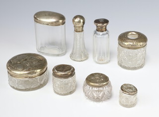 An Edwardian silver mounted circular cut glass toilet jar decorated with Reynolds angels Birmingham 1904 and 7 other mounted items 