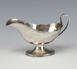 A silver sauce boat of simple form with scroll handle Birmingham 1938, 148 grams