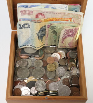 A quantity of various bank notes and foreign coins contained in a wooden box