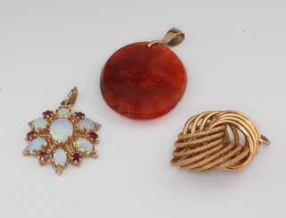 A 9ct yellow gold opal and garnet pendant, a yellow metal pendant and a hardstone pendant 