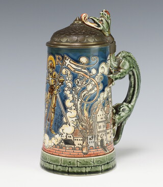 A German ceramic stein with metal lid, the body decorated with a townscape having a dragon handle 21cm 