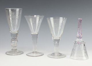 A George VI engraved commemorative glass goblet 1937 with inset coin to stem 25cm, an Elizabeth II ditto with engraved inscription 19cm, another 17cm and a glass bell with coloured glass twist handle 19cm (no clapper)