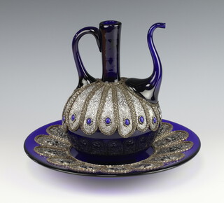 A Persian blue glass ewer with wire metal repousse mounts and a ditto tray 
