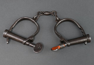 A pair of Hiatt handcuffs and key marked 104 
