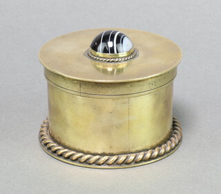 A brass cylindrical jar and cover the lid set a cabochon cut stone 6cm x 10cm