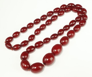 A red amberoid graduated bead necklace 84cm 