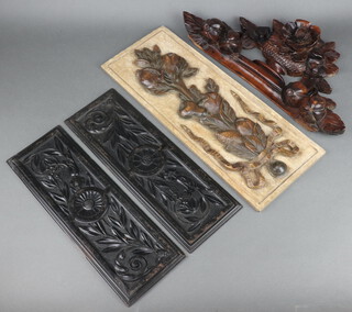 A Victorian carved and pierced mahogany pediment in the form a basket of flowers   26cm x 47cm, a rectangular carved limed wood panel decorated fruits 50cm x 19cm and a pair of Victorian carved ebonised panels 40cm x 13cm  