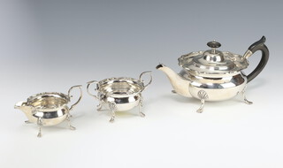 An Edwardian silver breakfast tea set with ebony mounts, comprising teapot, sugar bowl and cream jug, raised on pad feet, London 1906 and 1907, 587 grams gross 