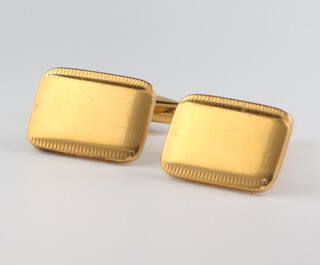 A pair of yellow metal engine turned cufflinks 