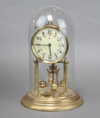 Kundo, a 400 day clock with enamelled dial and Roman numerals in a gilt case, complete with glass dome 31cm h x 17cm diam. 