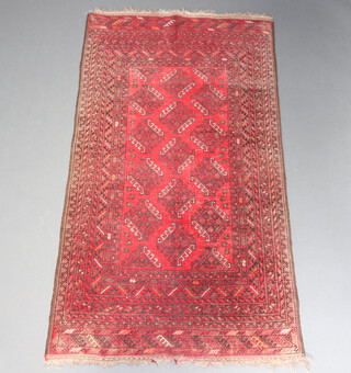A red and black ground Afghan rug with diamond medallion to the centre within a multi row border 190cm x 104cm 