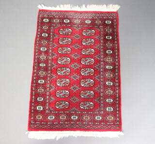 A red and white ground Bokhara rug with 16 octagons to the centre within a multi row border 119cm x 79cm 