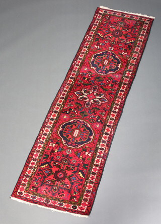 A red, blue and green ground Persian runner with 2 medallions to the centre 220cm x 64cm 