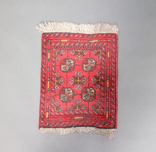 A red and brown ground Afghan slip rug with 4 octagons to the centre 56cm x 42cm 