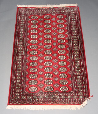A red and black ground Bokhara rug with 42 octagons to the centre within a multi row border 191cm x 121cm 