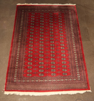 A red and black ground Bokhara carpet with 80 octagons to the centre within a multi row border 284cm x 208cm 