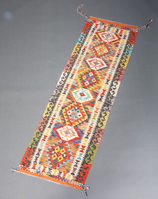 A green, white and orange ground Chobi Kilim runner with diamond design to the centre within in a multi row border 198cm x 61cm 