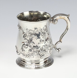 A George II repousse silver baluster mug decorated with fruits and flowers, having a vacant cartouche with S scroll handle, London 1748, 317 grams, maker FW? 12cm 