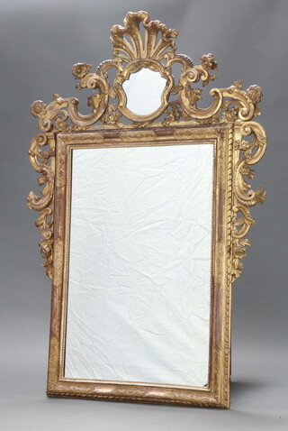 A 19th Century rectangular plate mirror contained in a Rococo style carved  wooden and pierced gilt painted frame 178cm x 120cm 
