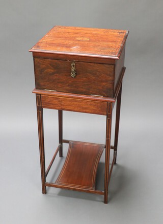 An Edwardian inlaid mahogany dressing cabinet, the hinged lid fitted a mirror above fall front, the interior fitted a drawer (handle missing), raised on square tapered supports with shaped undertier 77cm h x 36cm w x 36cm d 