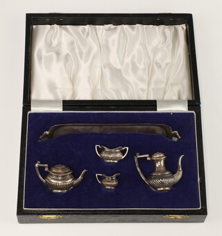 A miniature silver tea and coffee set comprising teapot, coffee pot, milk jug, sugar bowl and tray, cased Birmingham 1972, 67 grams