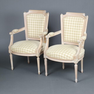 A pair of 18th Century style bleached wood open arm salon chairs, the seats and backs upholstered in green and white material, raised on turned and fluted supports 85cm h x 56cm w x 46cm d 