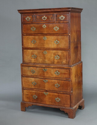A George II walnut chest on chest, inlaid with satinwood stringing, having a moulded cornice to the top and quarter veneered sides, the upper section fitted 3 short drawers above 3 long drawers, the base fitted 3 long drawers, with original pierced brass handles, raised on bracket feet  178cm x 100cm w x 53cm d 